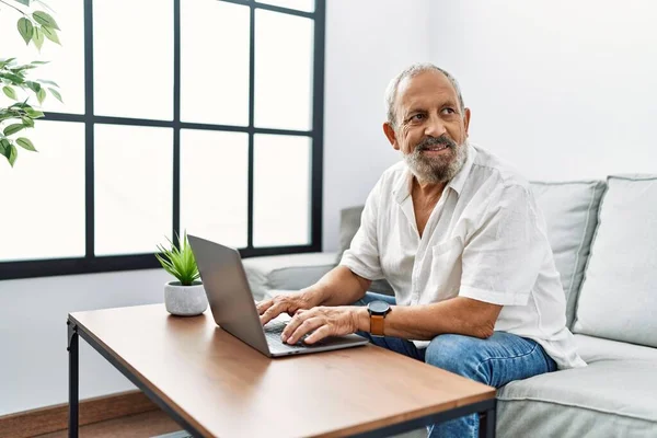 Älterer Grauhaariger Mann Lächelt Selbstbewusst Mit Laptop Hause — Stockfoto