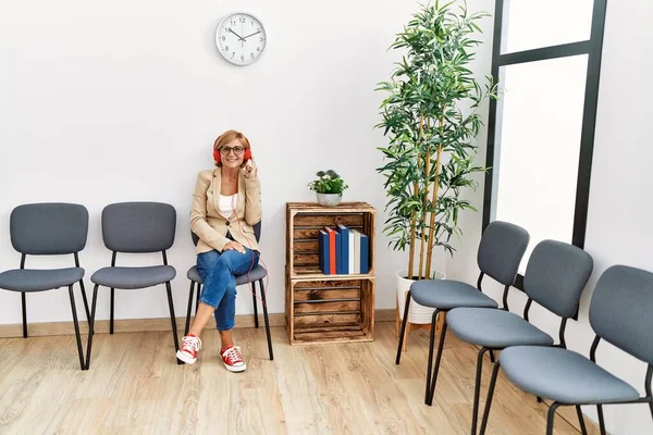 Middle Age Blonde Woman Smiling Confident Listening Music Waiting Room — Φωτογραφία Αρχείου