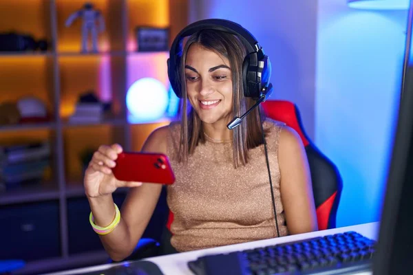 Молодая Латиноамериканка Играющая Видеоигры Смартфоном Выглядит Позитивно Счастливо Стоя Улыбаясь — стоковое фото