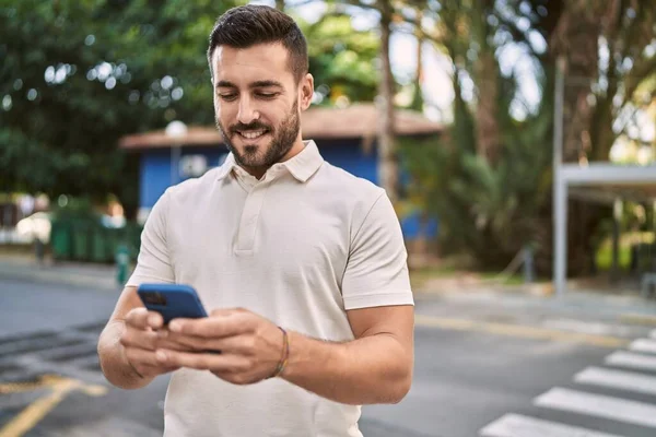 Sokakta akıllı telefon kullanan, kendine güvenen genç bir İspanyol.