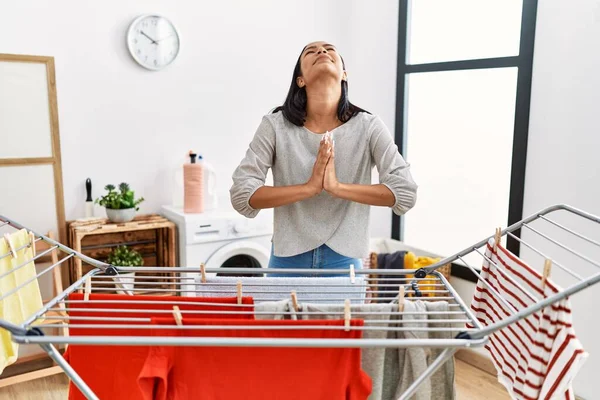 Young Hispanic Woman Putting Fresh Laundry Clothesline Begging Praying Hands — Stock Photo, Image