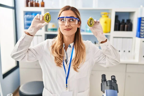若いですブロンド科学者女性作業とともに食べ物で実験室で笑顔を見ます側に見て離れて考えます — ストック写真