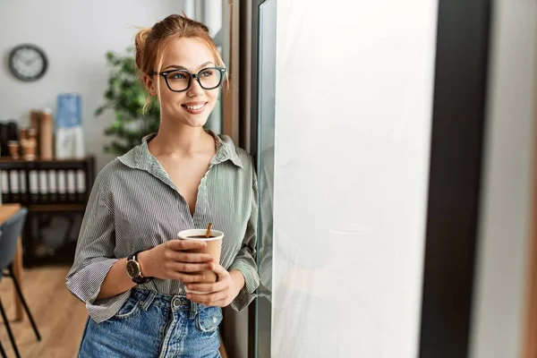 若い白人女性ビジネスマンオフィスで自信を持ってコーヒーを飲む笑顔 — ストック写真