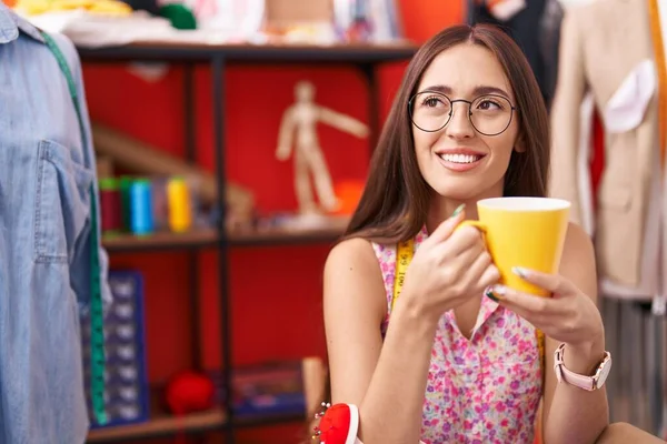 年轻美丽的惊慌失措的女人裁缝店里自信地微笑着喝咖啡 — 图库照片