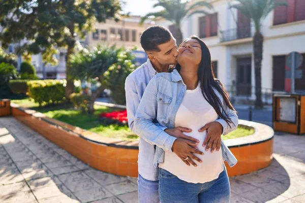 一对年轻的拉丁夫妇期待着宝宝拥抱在一起 亲吻公园 — 图库照片