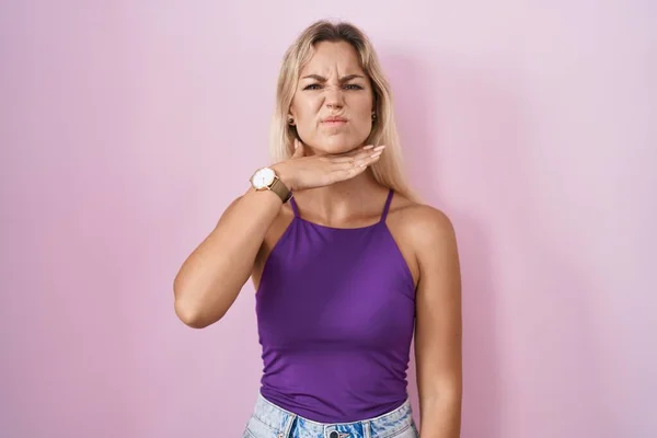 Jonge Blonde Vrouw Staande Roze Achtergrond Snijden Keel Met Hand — Stockfoto