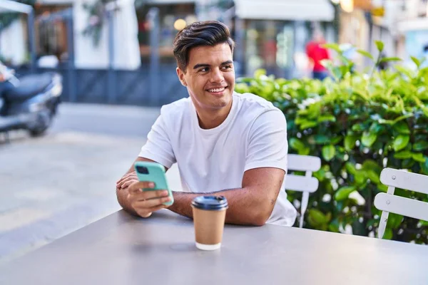 在咖啡店露台用智能手机喝咖啡的年轻人 — 图库照片