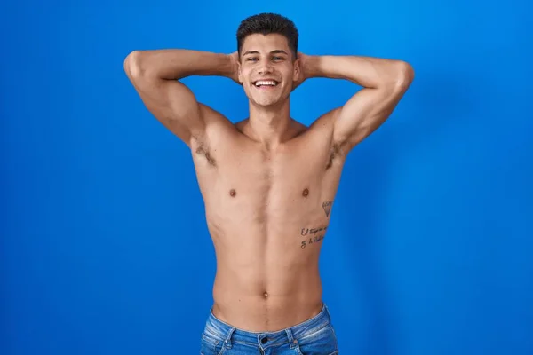 Junger Hispanischer Mann Steht Hemdlos Vor Blauem Hintergrund Und Entspannt — Stockfoto