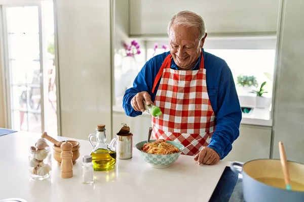 Ηλικιωμένος Χαμογελάει Αυτοπεποίθηση Ρίχνοντας Ρίγανη Στα Μακαρόνια Στην Κουζίνα — Φωτογραφία Αρχείου