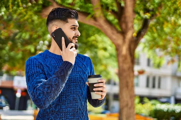 stock image Young arab man talking on the smartphone drinking coffee at park