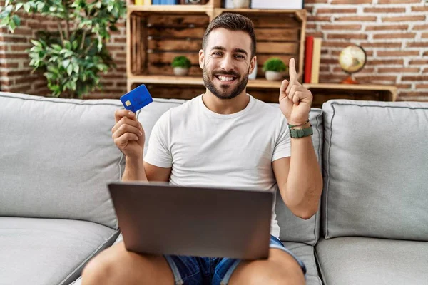 Красивий Іспаномовний Чоловік Робить Онлайн Покупки Тримаючи Кредитну Картку Посміхаючись — стокове фото