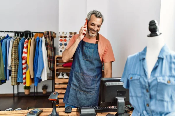 中年白发人售货员在服装店用智能手机聊天 — 图库照片