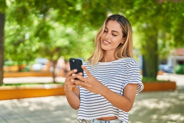 Νεαρή Ξανθιά Γυναίκα Χαμογελά Αυτοπεποίθηση Χρησιμοποιώντας Smartphone Στο Πάρκο — Φωτογραφία Αρχείου