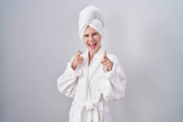 金发女人穿着浴衣 手指指向镜头 脸上洋溢着欢乐和滑稽的表情 充沛的精力和活力 — 图库照片