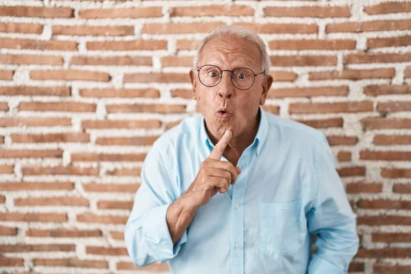 Ein Älterer Mann Mit Grauen Haaren Steht Über Einer Ziegelmauer — Stockfoto