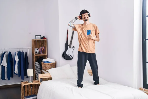 Молодой Латиноамериканец Слушает Музыку Танцует Кровати Спальне — стоковое фото