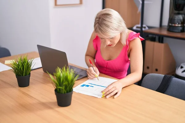 Genç Sarışın Kadını Ofisteki Evraklarda Dizüstü Bilgisayar Kullanıyor — Stok fotoğraf