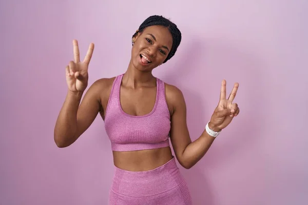 African American Woman Braids Wearing Sportswear Pink Background Smiling Tongue — Zdjęcie stockowe