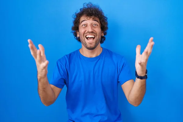 Hispanic Young Man Standing Blue Background Celebrating Crazy Amazed Success — стокове фото