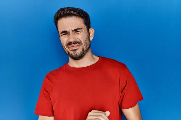 Young Hispanic Man Beard Wearing Red Shirt Blue Background Disgusted — Stok fotoğraf