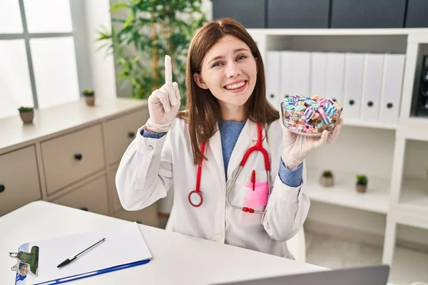 Young Doctor Woman Holding Sweets Candy Surprised Idea Question Pointing — Stock Photo, Image