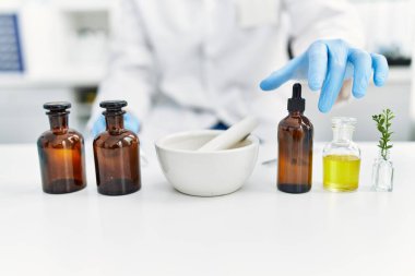 Laboratuvarda bilimsel havan topu kullanan yakışıklı İspanyol.