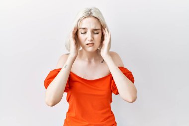 Kafkas kökenli genç bir kadın, elleri başının üstünde, izole bir şekilde duruyor, stres yüzünden baş ağrısı çekiyor. migren ağrısı. 