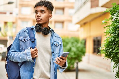 Sokakta akıllı telefon kullanan İspanyol genç adam.