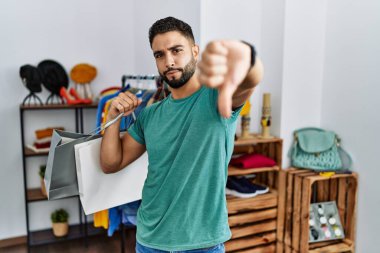 Perakende mağazasında sakallı yakışıklı bir adam mutsuz ve sinirli görünüyor. Reddedilmiş ve olumsuz. kötü ifade. 