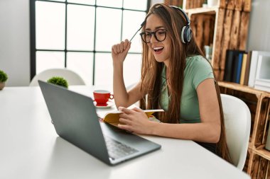 Evdeki masada oturan Latin asıllı genç bir kadın.