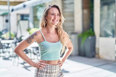 Young blonde woman smiling confident looking to the side at street