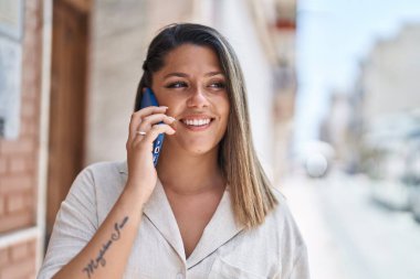 Genç İspanyol kadın gülümsüyor. Kendine güveniyor. Akıllı telefondan konuşuyor.