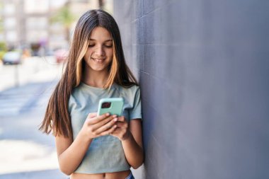 Adorable girl smiling confident using smartphone at street