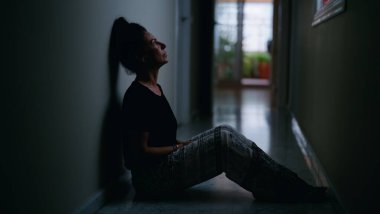 Orta yaşlı İspanyol kadın aile içi şiddet yüzünden acı çekiyor. Gözlerinde morluklar var. Evinde yerde oturuyor.