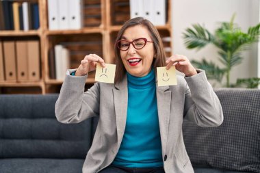 Orta yaşlı İspanyol kadın depresyonda. Mutluluktan mutluluk kağıdına sarılıp kameraya seksi bir ifadeyle bakıyor. Neşeli ve mutlu bir yüz.. 