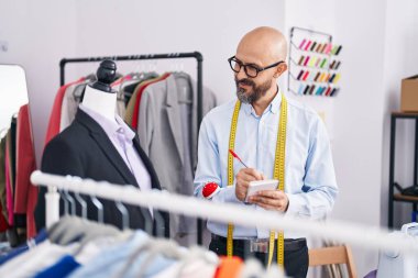 Genç kel adam terzi dükkanında kendine güvenen kendine güvenen bir terzi.