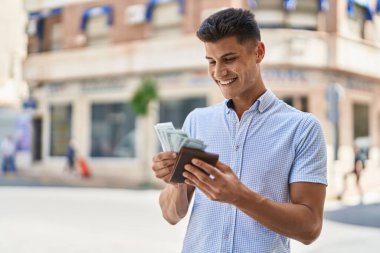 Genç İspanyol adam gülümsüyor. Kendine güveni tam. Sokakta dolarlarla cüzdan tutuyor.