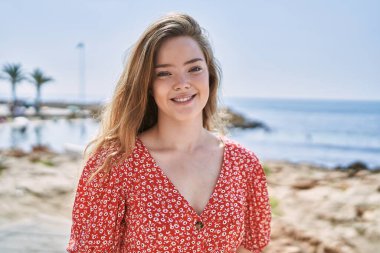 Young caucasian girl smiling confident at seaside