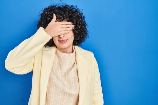 Young Brunette Woman Curly Hair Standing Blue Background Covering Eyes — Stock Photo, Image