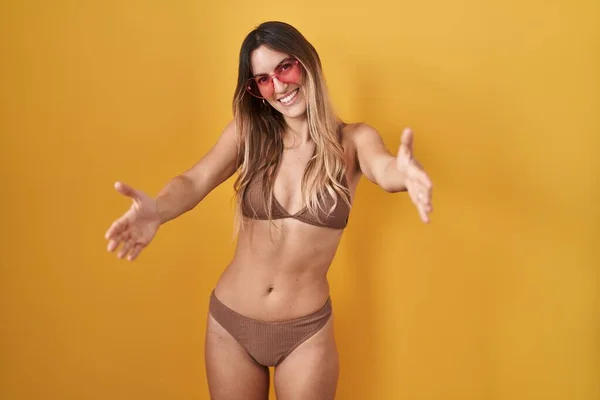 Mujer Hispana Joven Vistiendo Bikini Sobre Fondo Amarillo Mirando Cámara —  Fotos de Stock