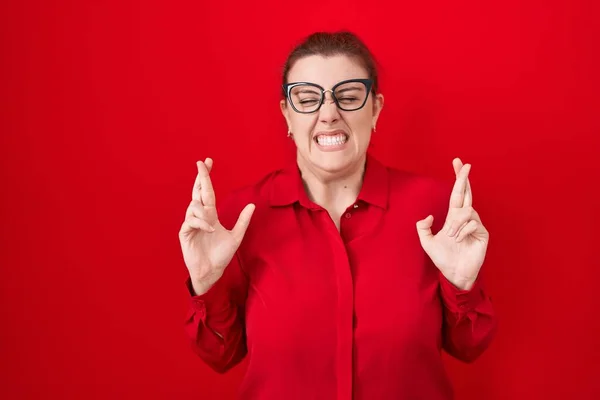 Young Hispanic Woman Red Hair Standing Red Background Gesturing Finger —  Fotos de Stock