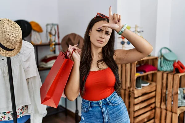 Genç Esmer Kadın Perakende Mağazasında Alışveriş Torbaları Tutuyor Alnında Parmakları — Stok fotoğraf