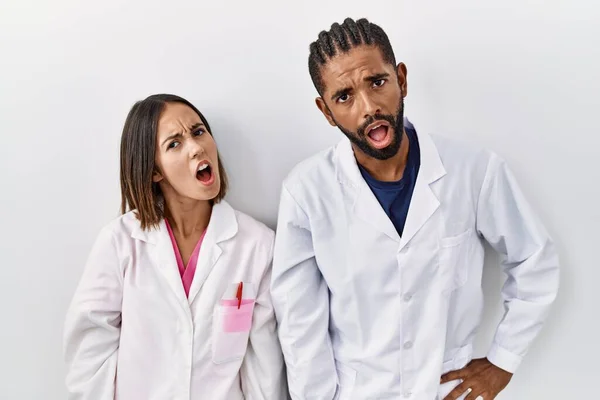 Young Hispanic Doctors Standing White Background Shock Face Looking Skeptical —  Fotos de Stock