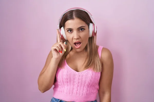 Mujer Rubia Joven Escuchando Música Usando Auriculares Apuntando Con Dedo — Foto de Stock