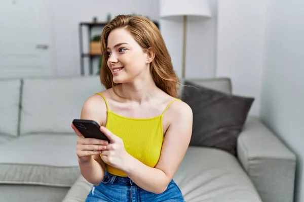 Young Redhead Girl Smiling Happy Using Smartphone Home — 图库照片