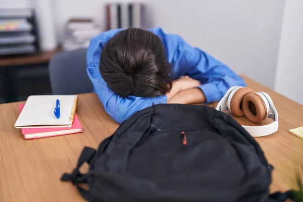 Adorable hispanic girl student stressed leaning on table at office