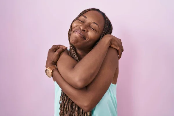 Afro Amerikaanse Vrouw Staat Roze Achtergrond Knuffelen Zichzelf Gelukkig Positief — Stockfoto