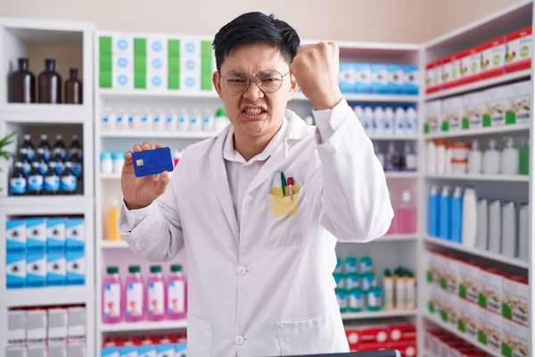 Young Asian Man Working Pharmacy Drugstore Holding Credit Card Annoyed — Stok fotoğraf