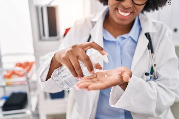非洲裔美国女医生在诊所的手上倒入清洁剂凝胶 — 图库照片