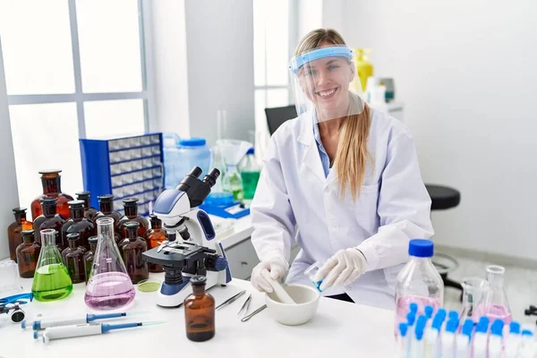 身穿科学家制服的金发女青年在实验室工作 — 图库照片